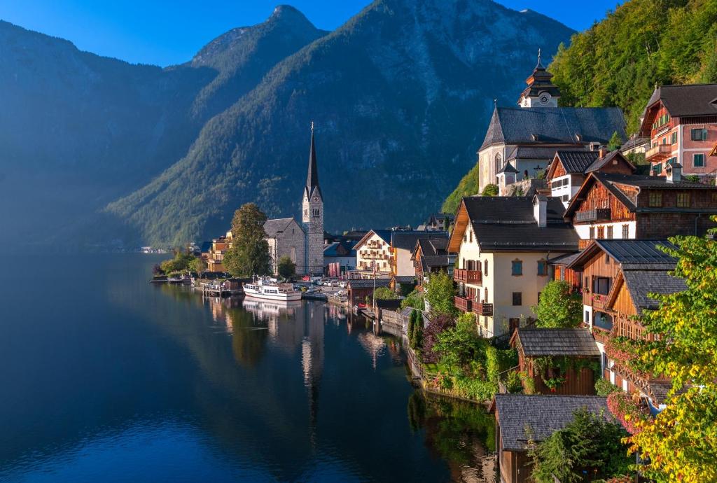 a town on a river with mountains in the background at W & S Executive Apartments - Hallstatt II in Hallstatt