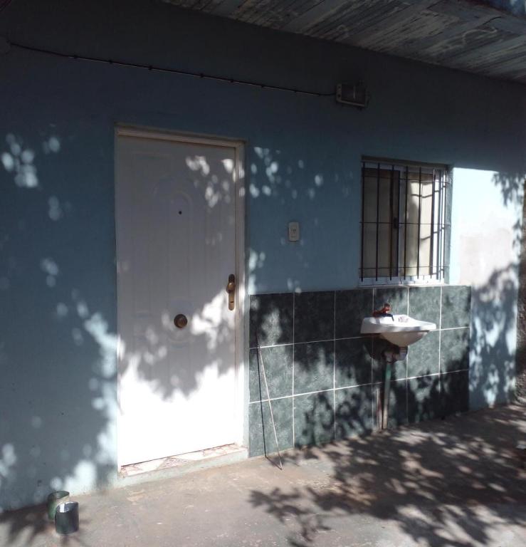 a blue house with a door and a sink at Hospedaje Espindoliky in Bella Vista
