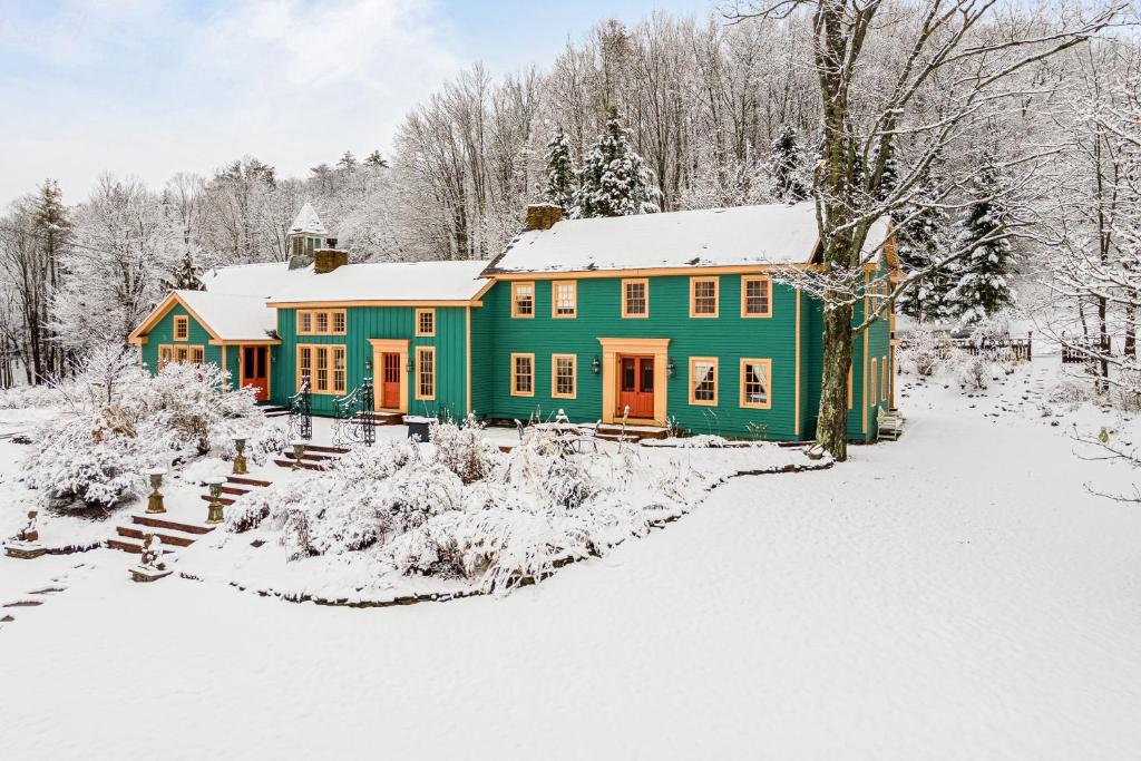 ein grünes Haus mit Schnee auf dem Hof in der Unterkunft The Schoolhouse - Unit B 