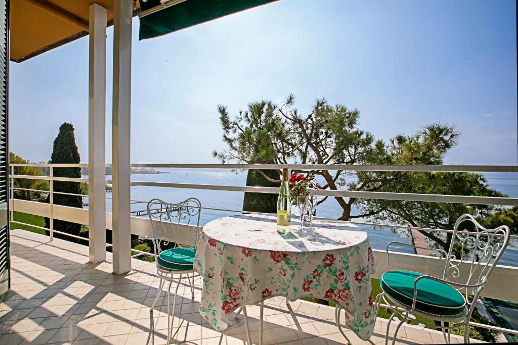シルミオーネにあるCasa Bel Tramontoのテーブルと椅子、水辺の景色を望むバルコニー