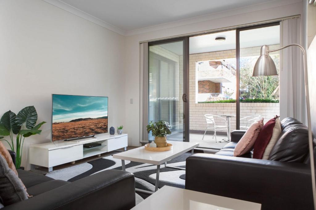 a living room with two couches and a tv at Spacious Two-Bedroom Apartment near Hospital in Sydney