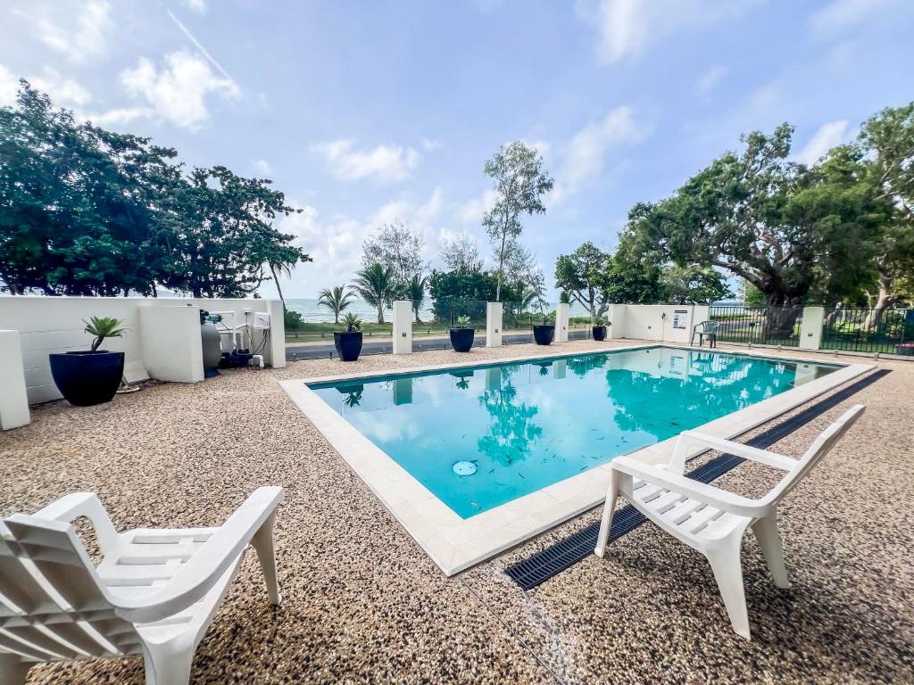 basen z dwoma białymi krzesłami obok niego w obiekcie La Riviera One - Coastal Lifestyle - Three Bedroom w mieście South Mission Beach