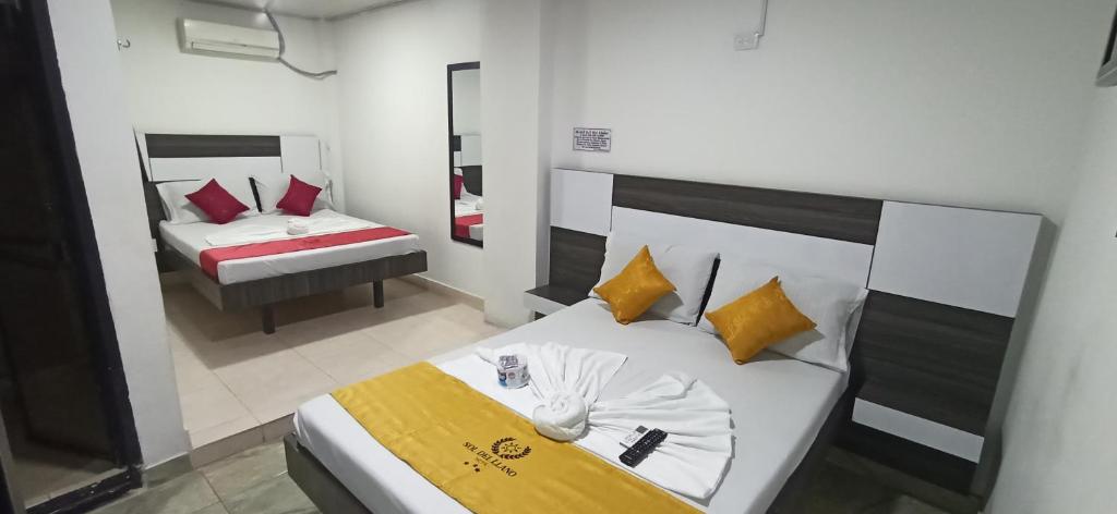 une chambre avec un lit et une chambre avec un miroir dans l'établissement Hotel Sol Del LLano, à Villavicencio