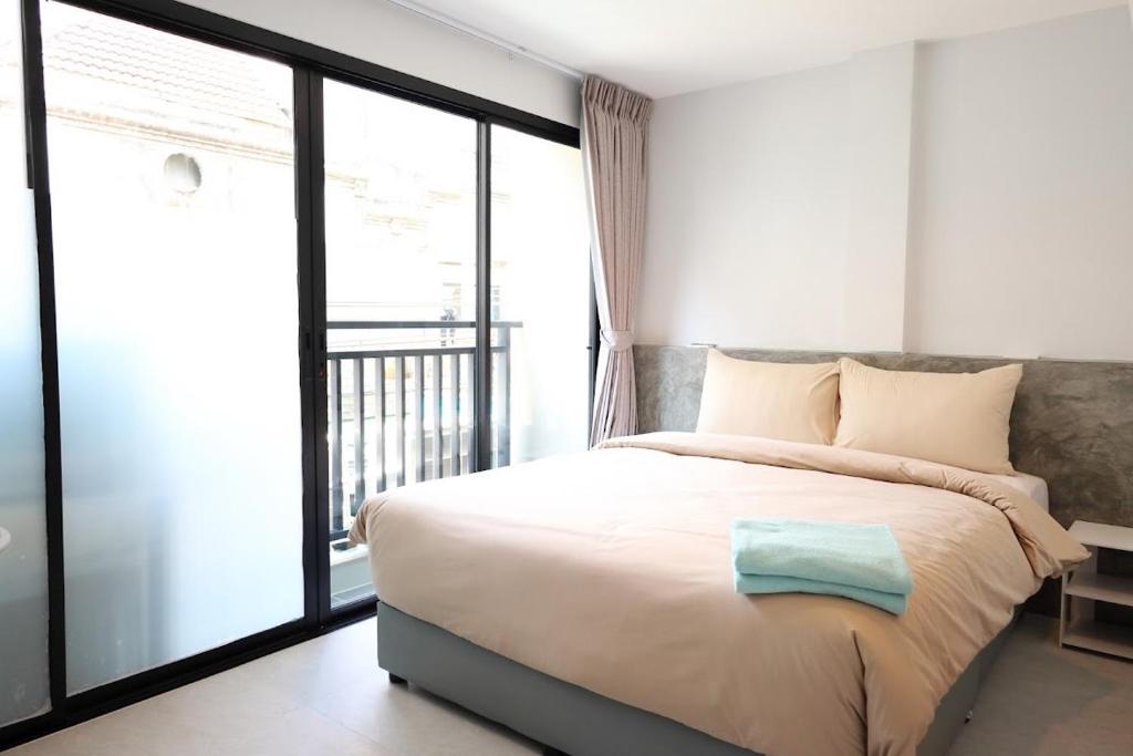a bedroom with a bed and a large window at Y House Patong in Patong Beach