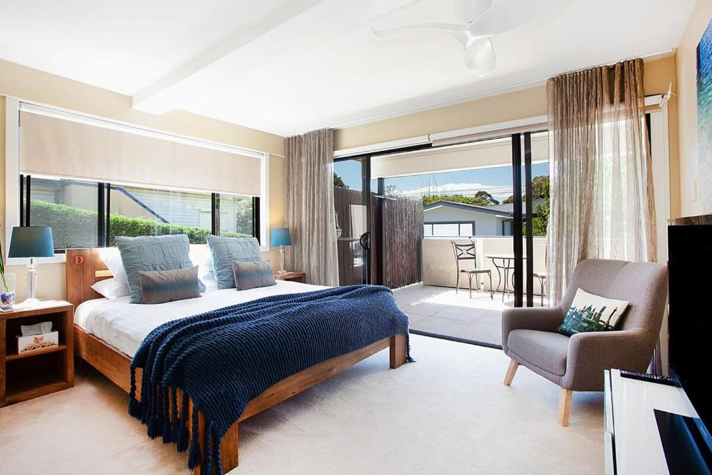 een slaapkamer met een bed en een stoel en een balkon bij Spacious Family Entertainer for Manly Retreat in Sydney