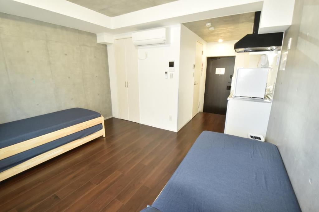 Habitación pequeña con cama y nevera. en Enzo iogi, en Tokio