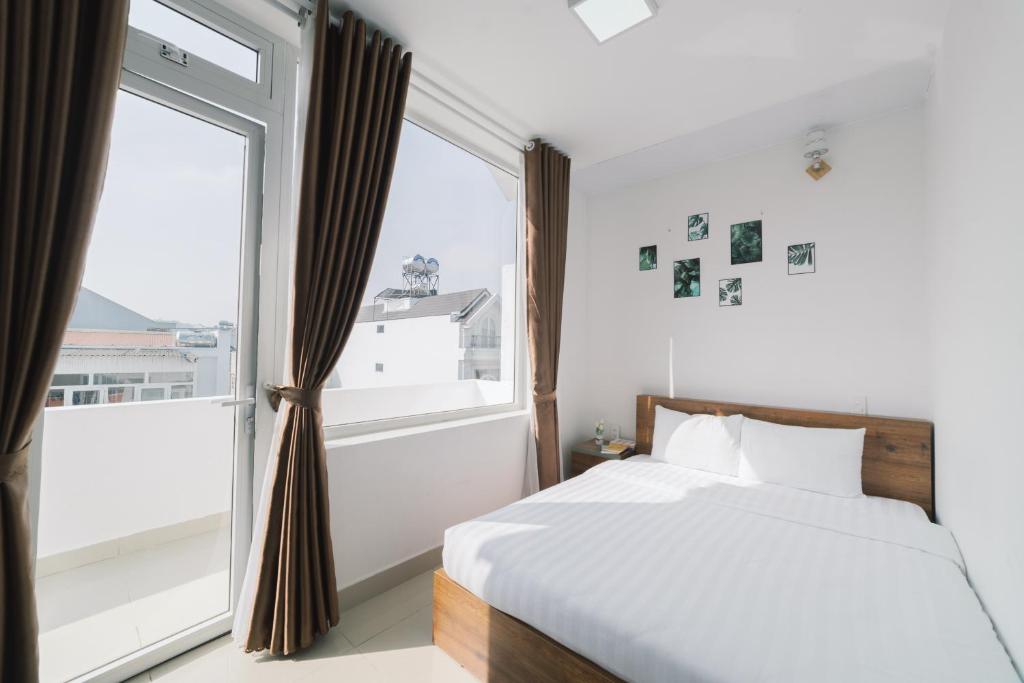 - une chambre avec un lit et une grande fenêtre dans l'établissement Mat Troi Vang Dalat Hotel, à Đà Lạt
