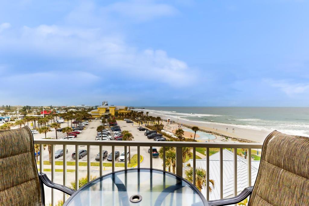 uma varanda com uma mesa e cadeiras e uma praia em Harbour Beach Resort Unit 518 em Daytona Beach