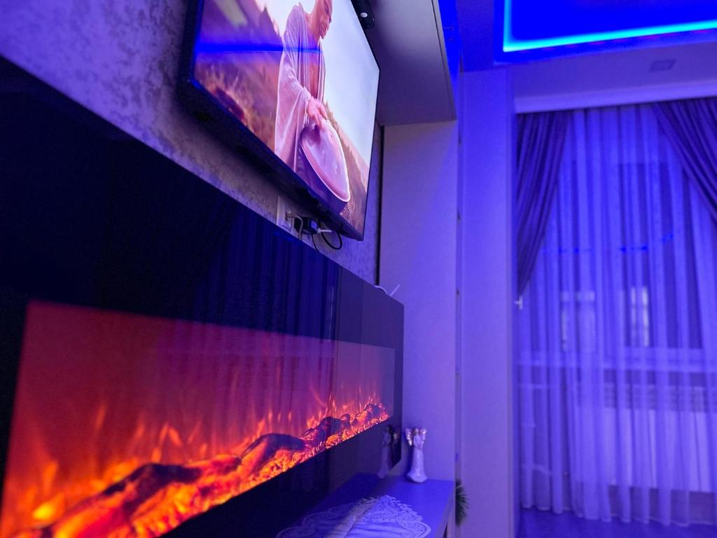 telewizor wiszący nad kominkiem w łazience w obiekcie Brand New Apartment Main Road w Kiszyniowie