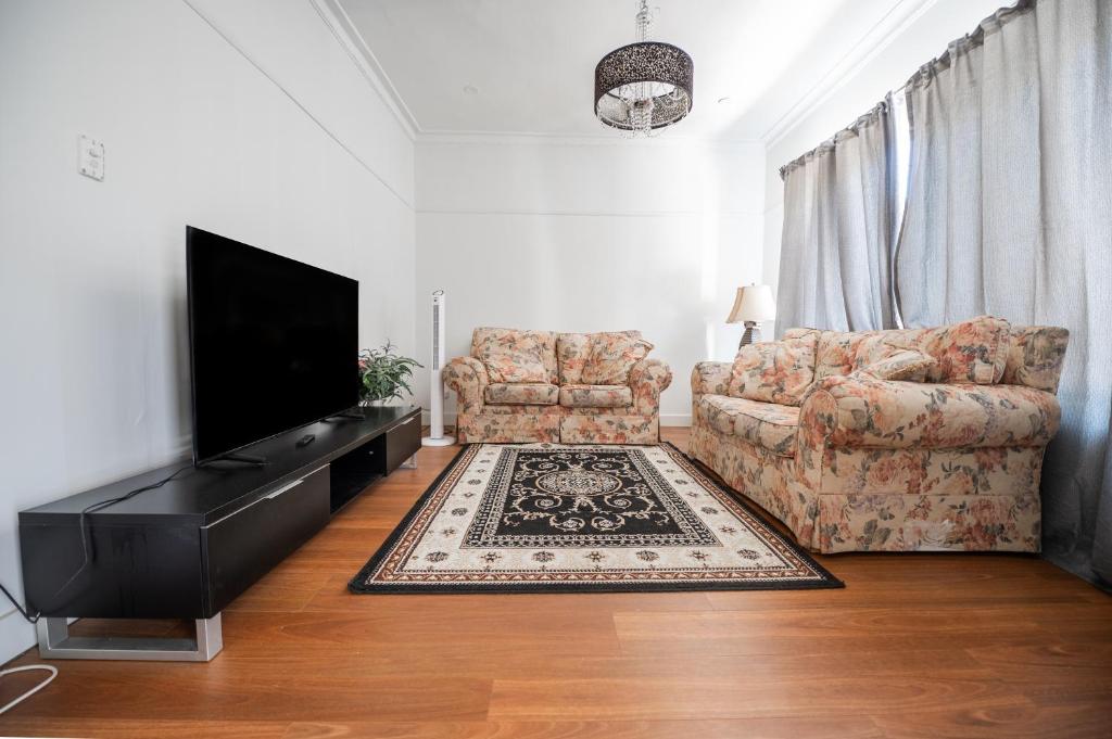 a living room with a couch and a television at Classic decor, freshly painted 3 by 2 quiet home in Corio