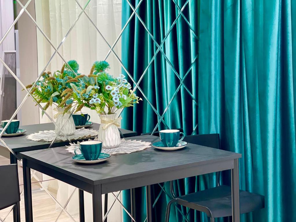 uma mesa com copos azuis e flores em New Luxury apartment em Chisinau