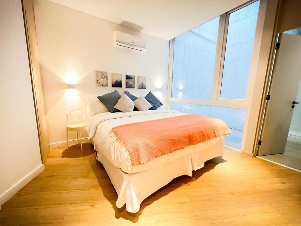 1 dormitorio con cama grande y ventana grande en LOFT ubicado en el corazón de Santiago, Lastarria en Santiago
