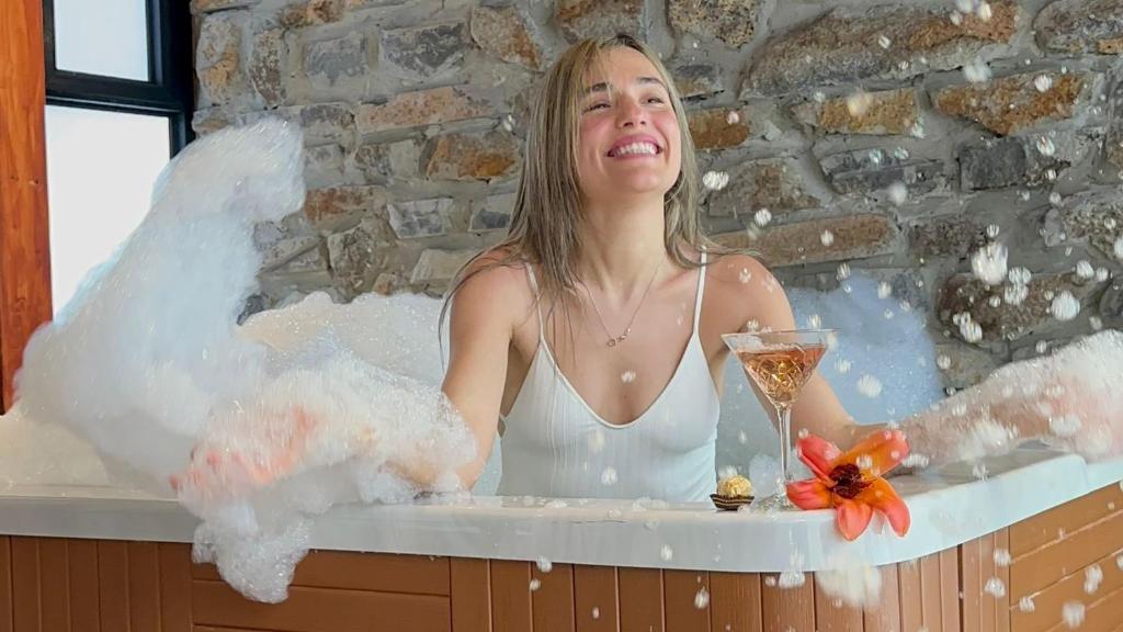 Una donna nella vasca da bagno con un bicchiere di champagne di Spa Village at Hamat Gader - adults only a Hamat Gader