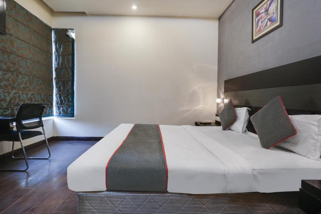Cette chambre comprend un grand lit et une chaise. dans l'établissement Collection O Hotel Cambridge, à Dhankot