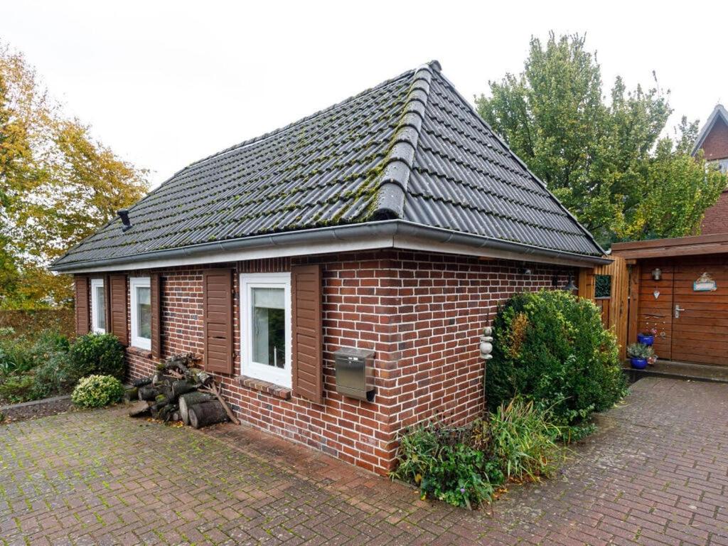 une maison en briques avec un toit en carrelage dans une allée. dans l'établissement Exclusive tiny house, à Buxtehude