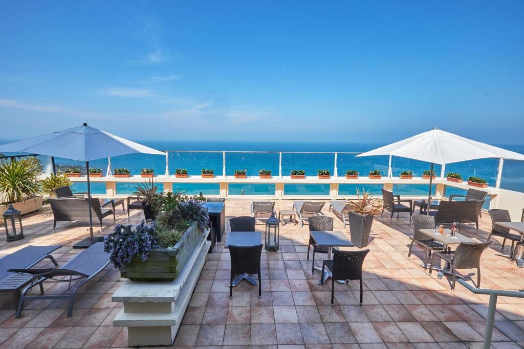 a patio with tables and chairs and a pool at Mercure Granville Le Grand Large in Granville