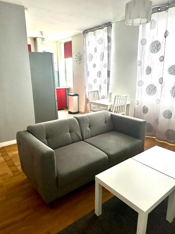 a living room with a couch and a table at Appartement Entier Montespan - Parking Privé in Évry-les-Châteaux