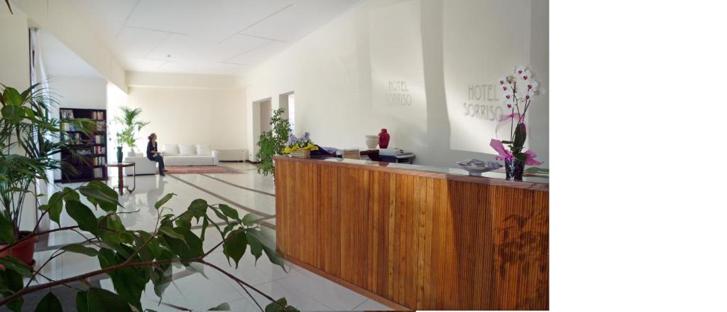 a lobby with a reception desk and plants at Hotel Sorriso in Venice-Lido