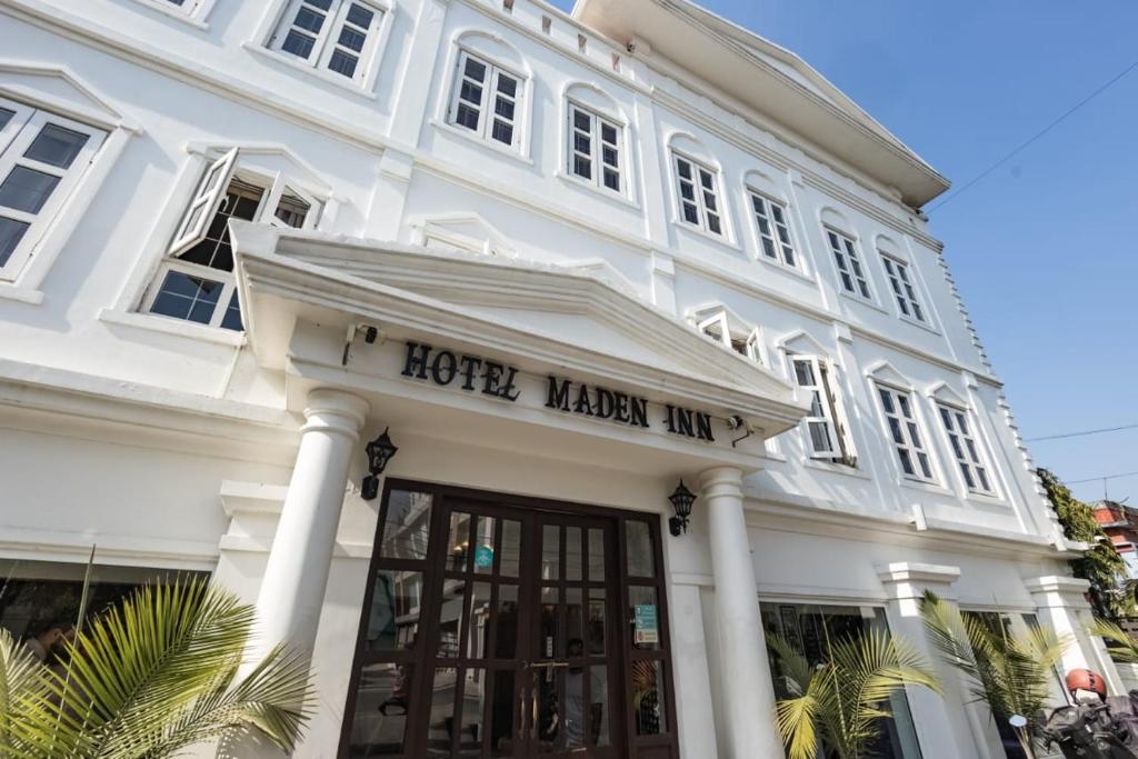 Hotel Maden Inn في Itahari: مبنى أبيض مع علامة صانع الفندق على النزل