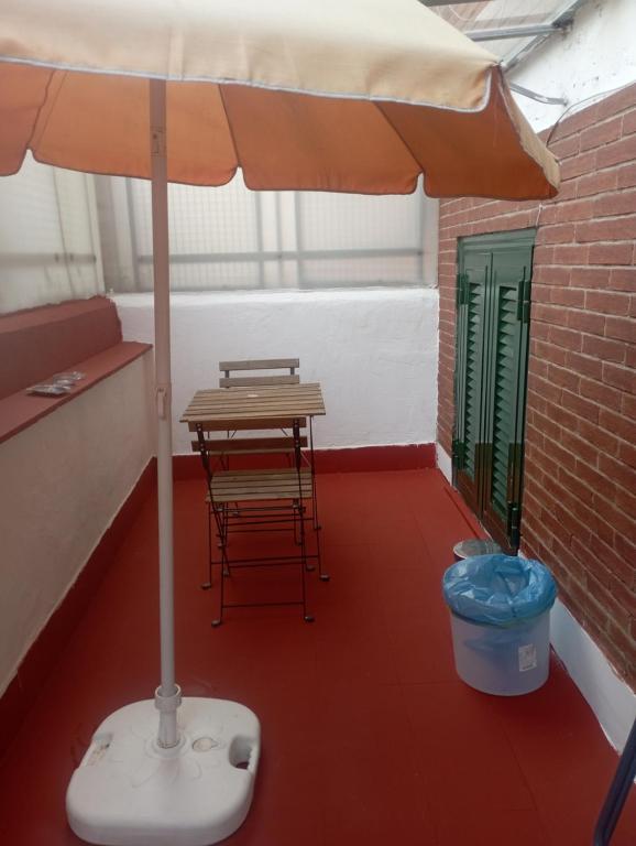 um guarda-chuva num quarto com uma mesa e uma lata de lixo em Pigneto House em Roma