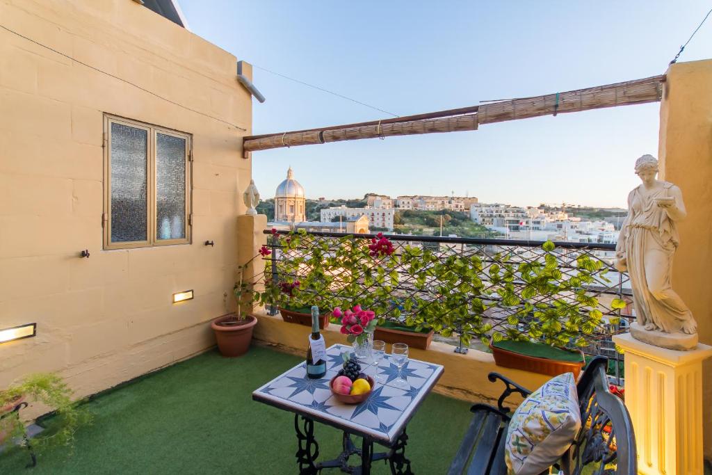einen kleinen Tisch auf einem Balkon mit Stadtblick in der Unterkunft Sunny Maltese townhouse Madonnina Kalkara - Happy Rentals in Kalkara