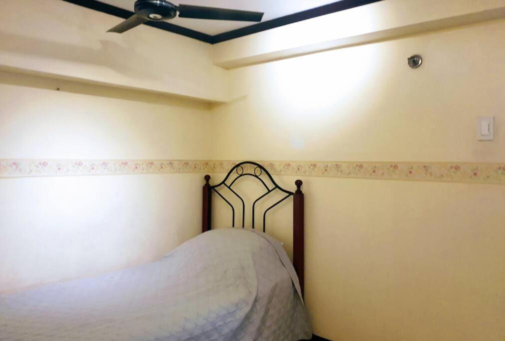 um quarto com uma cama e um tecto em Greenhills Garden Square em Manila