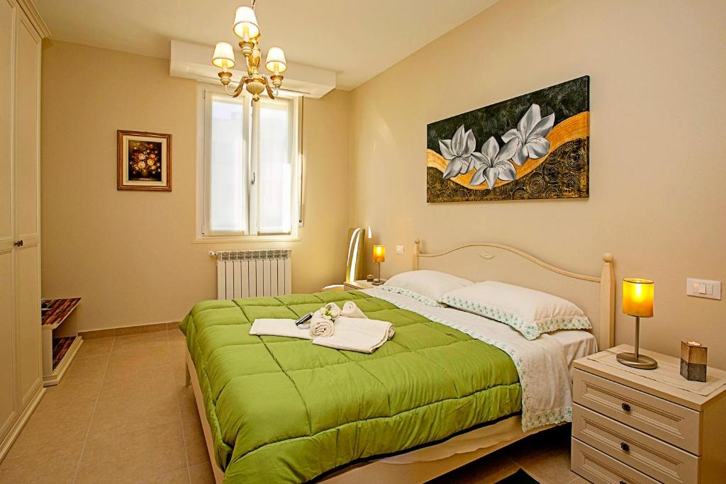 sypialnia z zielonym łóżkiem i oknem w obiekcie Villa Mimosa - Appartamento 2 - Happy Rentals w mieście Desenzano del Garda