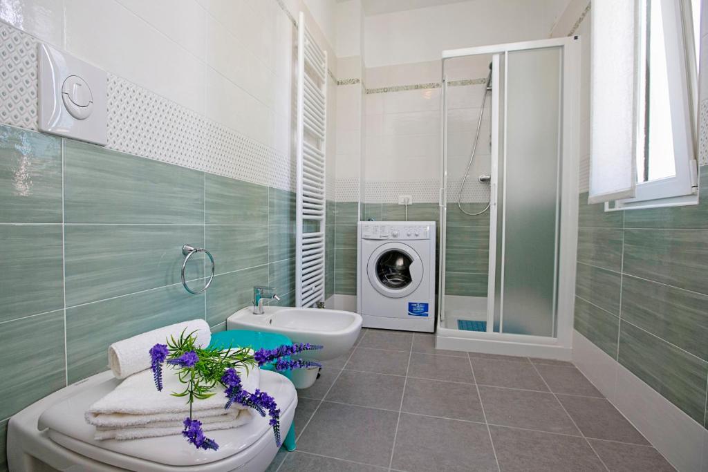 łazienka z toaletą i pralką w obiekcie Villa Mimosa - Appartamento 2 - Happy Rentals w mieście Desenzano del Garda