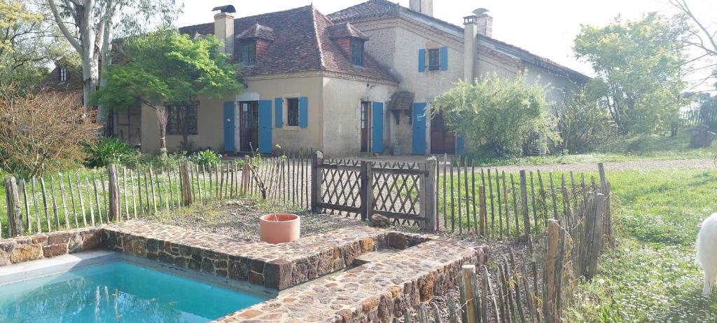 a house with a pool in front of a fence at Haou de campagne in Peyre