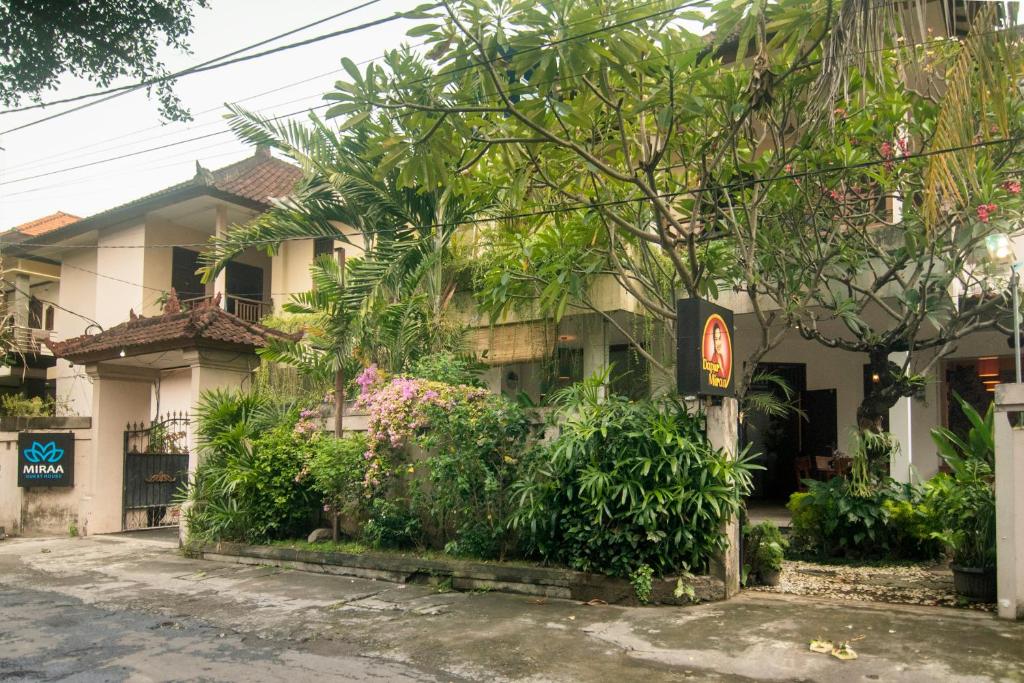 een gebouw met veel planten ervoor bij Miraa Guest House & Resto in Denpasar