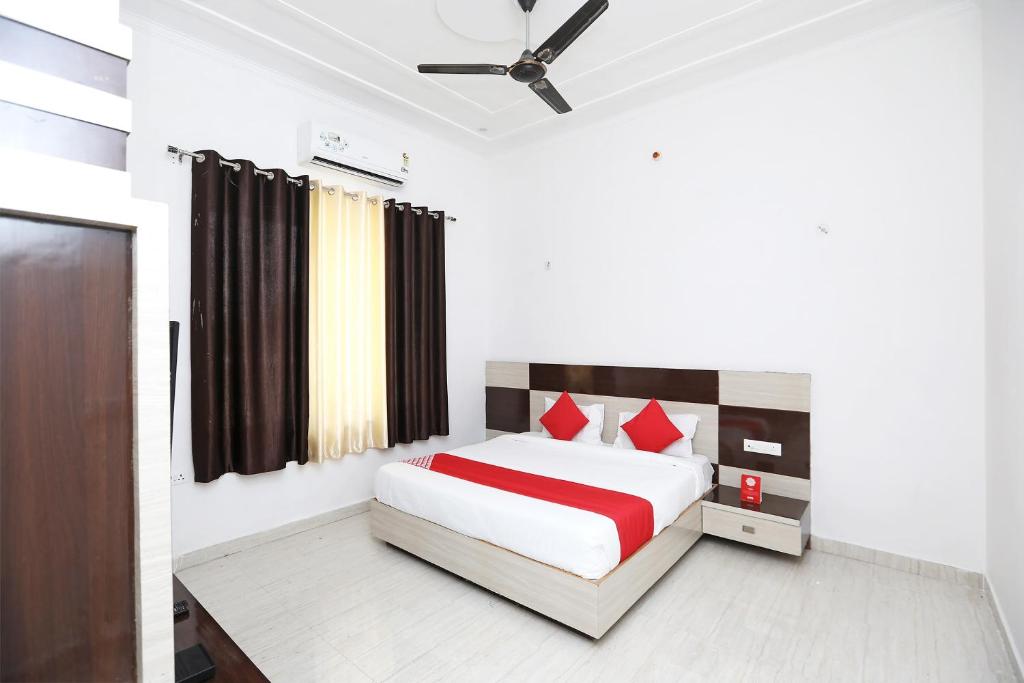 1 dormitorio con 1 cama grande con almohadas rojas en OYO Diamond Resort, en Alwar