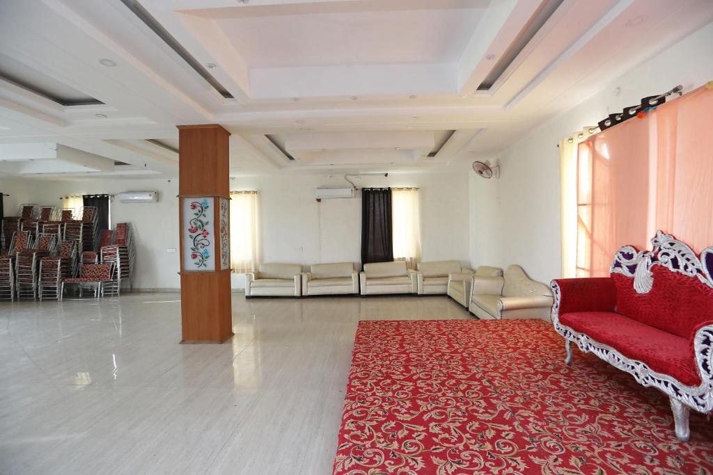 Großes Zimmer mit einem roten Teppich und Stühlen in der Unterkunft OYO Diamond Resort in Alwar