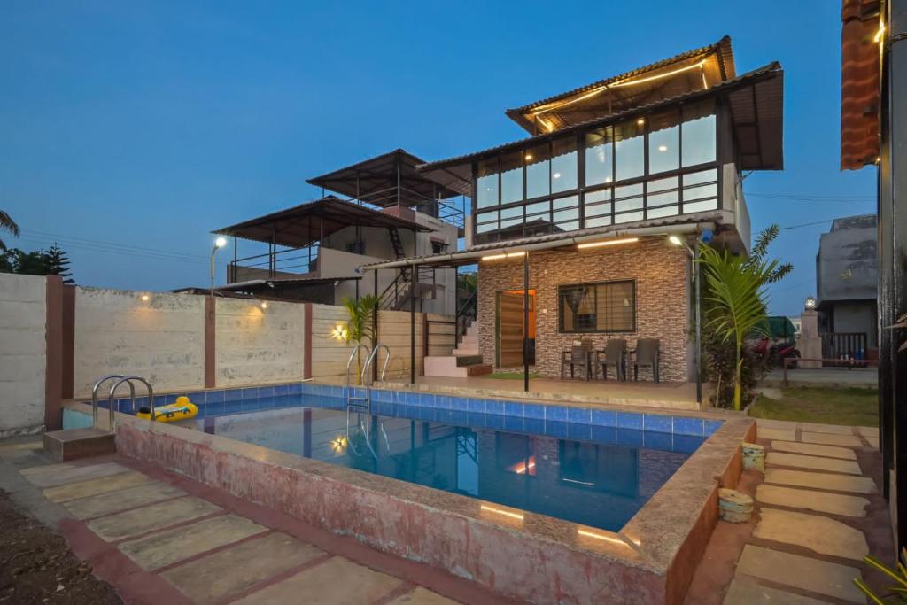 uma casa com piscina em frente a uma casa em Campion Villa em Lonavala