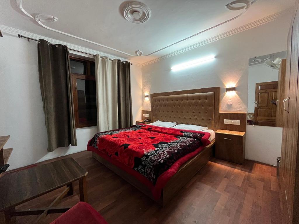 um quarto com uma cama com um edredão vermelho em Hotel Premier Mall Road Manali em Manali