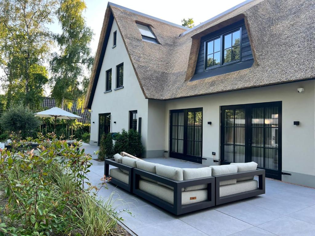 a house with a couch on a patio at Suite Heiloo in Heiloo