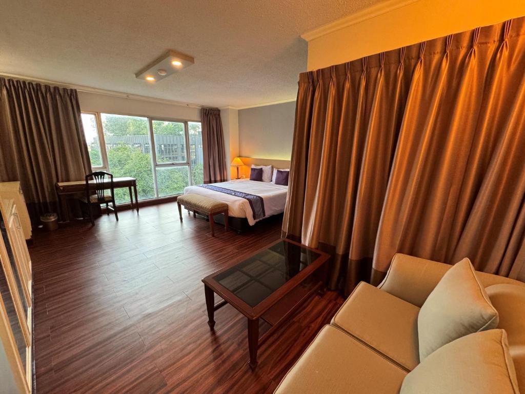 バンコクにあるザ ステップ サソーンのベッドとソファ付きのホテルルーム