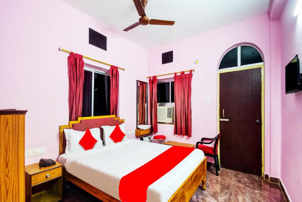 1 dormitorio con 1 cama con edredón rojo y blanco en Hotel Planet 9 Puri - Wonderfull Stay with Family Near Sea Beach, en Puri