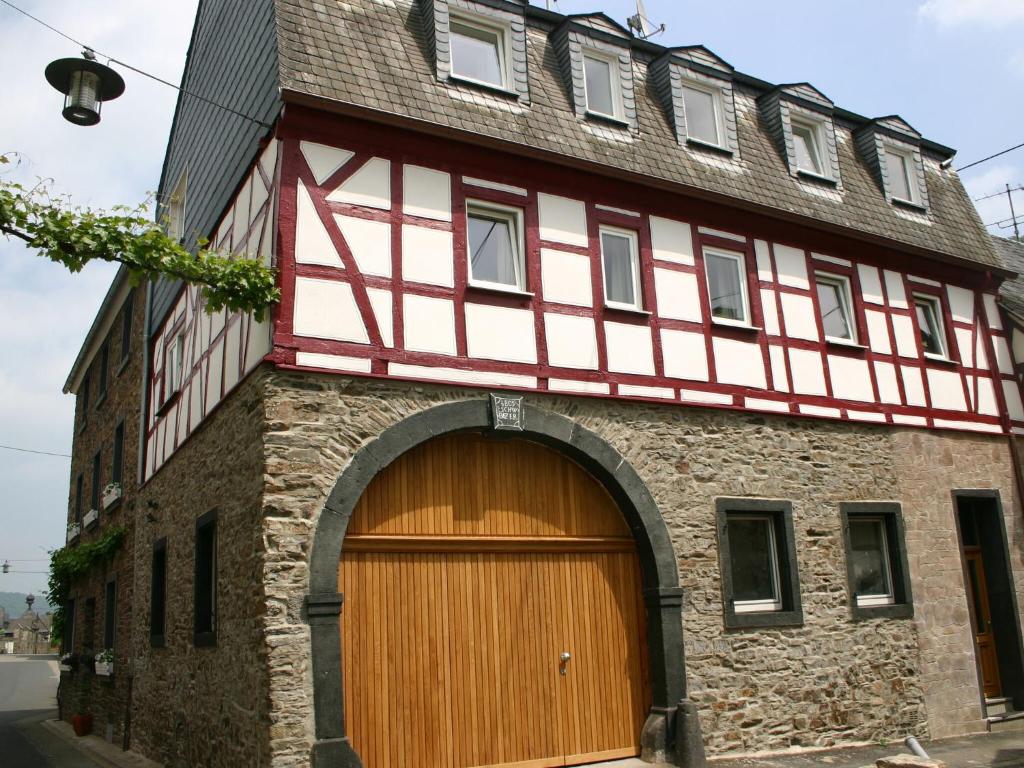 a building with a wooden garage door and a building at A modern holiday home by the River Mosel in Moselkern
