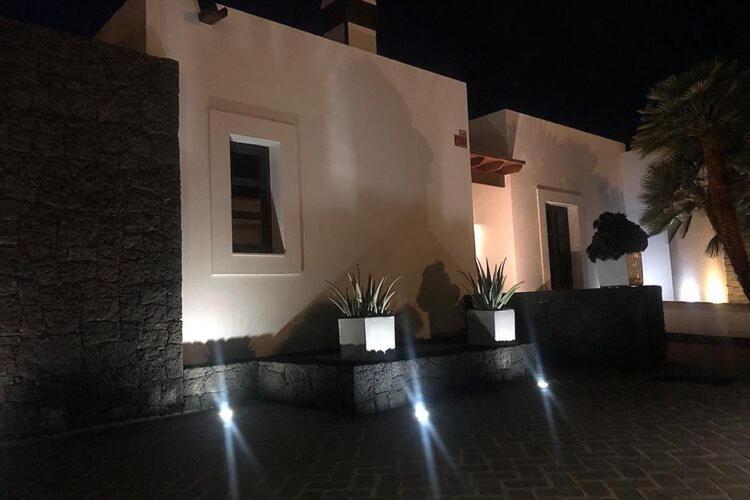 a building with two potted plants in front of it at night at Beautiful holiday home in Playa Blanca with pool in Playa Blanca