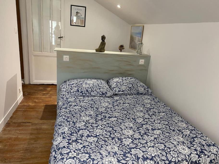um quarto com uma cama com um edredão azul e branco em Villa Soulacaise Plage et Centre em Soulac-sur-Mer