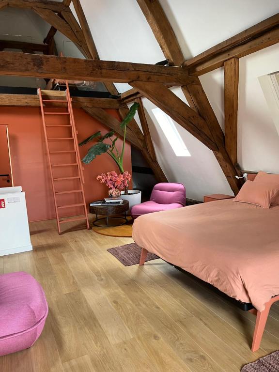 een slaapkamer met een bed en paarse stoelen bij Maison Brunon in Brugge