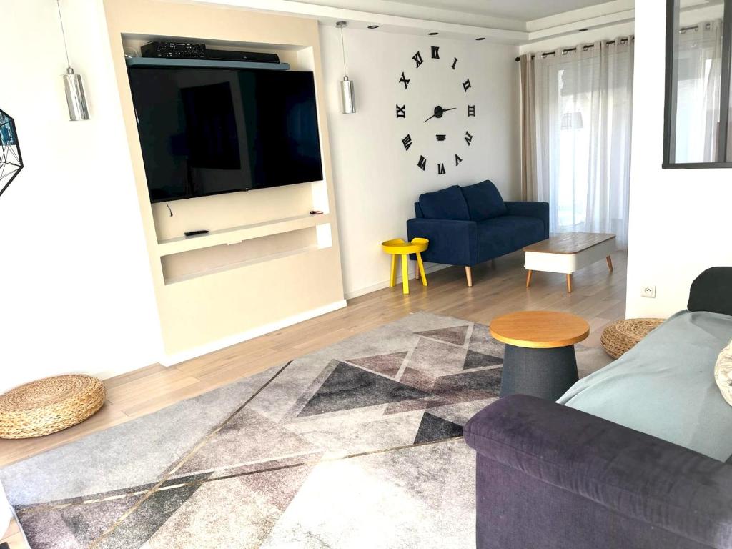 sala de estar con sofá azul y TV en Maison de 4 chambres avec jardin clos a Villepreux, en Villepreux