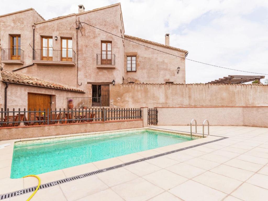 une villa avec une piscine en face d'une maison dans l'établissement 17th century farmhouse in Bages near Montserrat, à Castellfullit del Boix