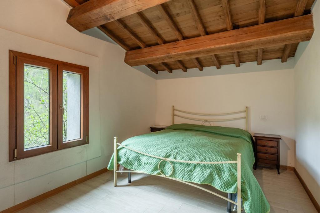 1 dormitorio con 1 cama con edredón verde en La rosa del vento, en Fabbriche di Vallico