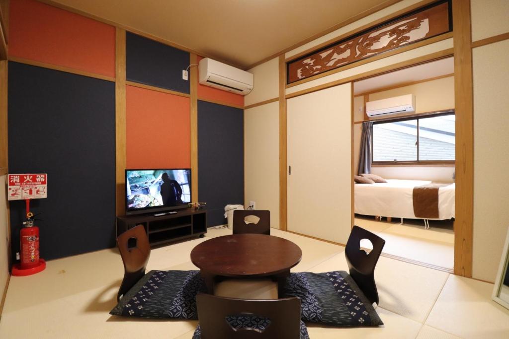 een kamer met een bed, een tafel en stoelen bij Tsuruhashi East III in Osaka