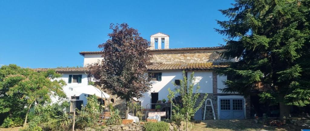 ein großes weißes Haus mit Bäumen davor in der Unterkunft Borgo San Michele Incisa Tuscany in Incisa in Valdarno