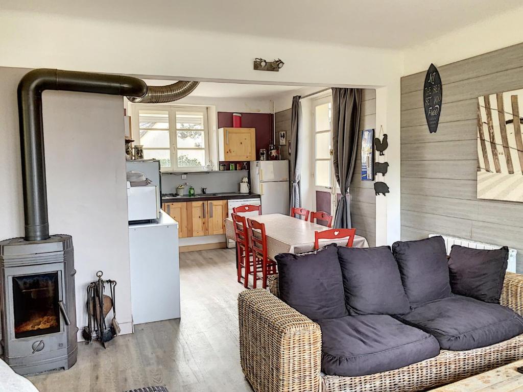 - un salon avec un canapé et une cuisinière dans l'établissement Villa Près de la Plage, Jardin, Proche Commerces, 4 Ch, Wifi, Idéale Familles - FR-1-361-15, à Jullouville