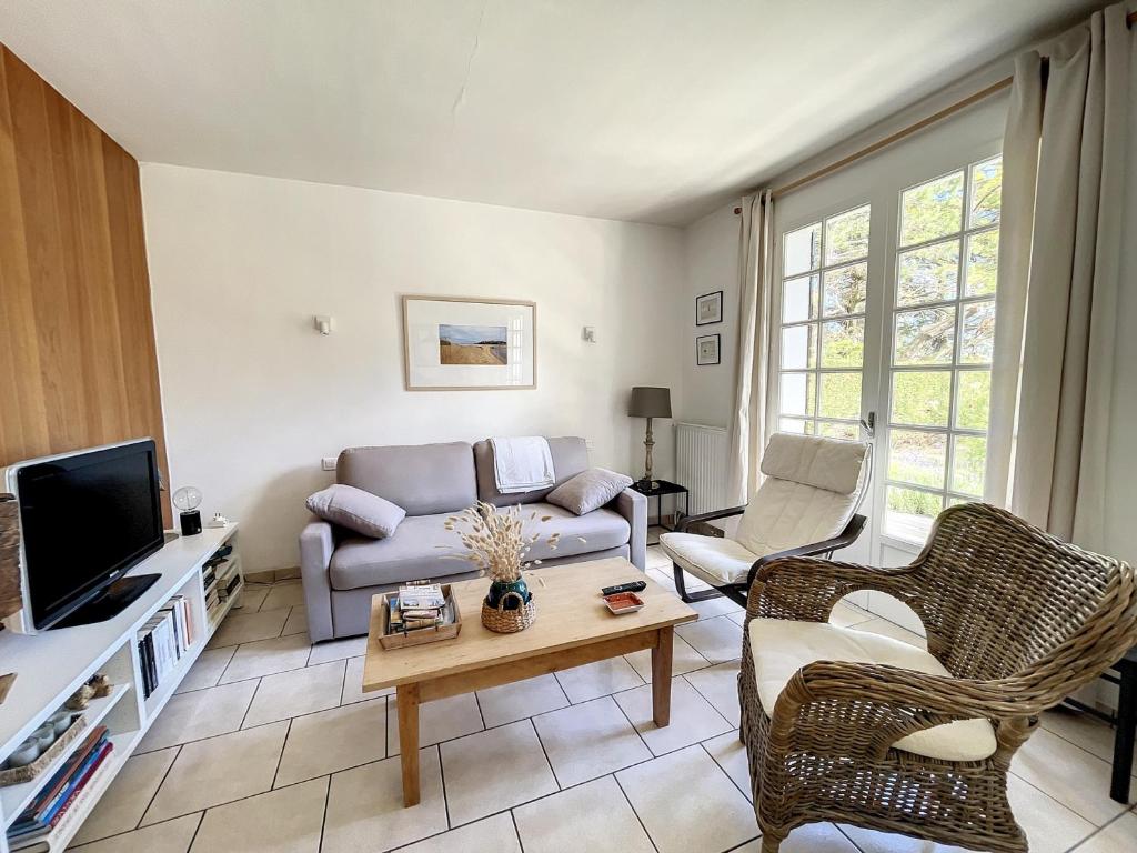 a living room with a couch and a tv at Maison Saint-Pair-sur-Mer, 5 pièces, 8 personnes - FR-1-361-56 in Saint-Pair-sur-Mer