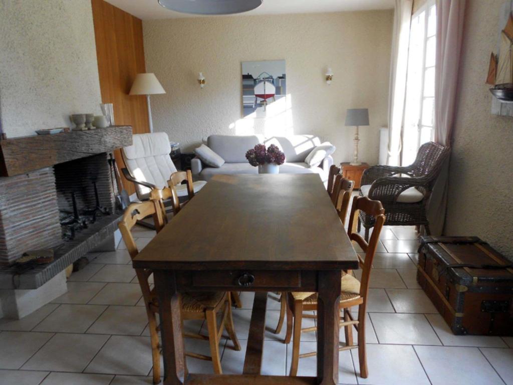 a living room with a wooden table and chairs at Maison Saint-Pair-sur-Mer, 5 pièces, 8 personnes - FR-1-361-56 in Saint-Pair-sur-Mer