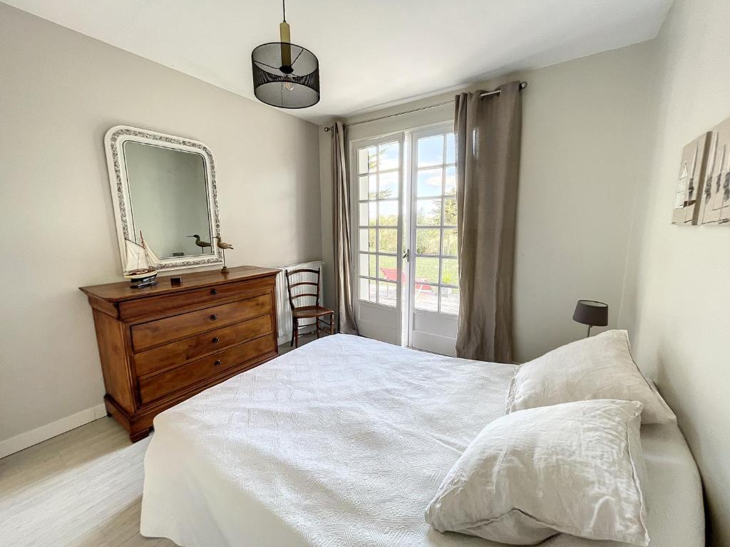 a bedroom with a bed and a mirror and a dresser at Maison Saint-Pair-sur-Mer, 5 pièces, 8 personnes - FR-1-361-56 in Saint-Pair-sur-Mer